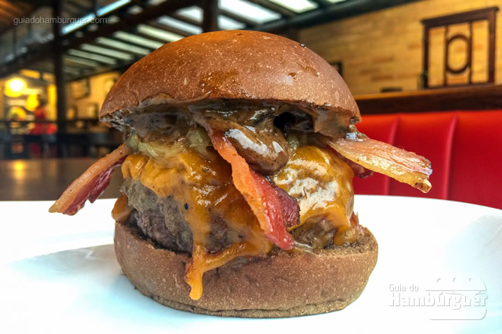 Hambúrguer de 180g, queijo cheddar inglês, cebola caramelizada, bacon em tiras e maionese de alho negro no pão preto - Desafio Chip's Burger