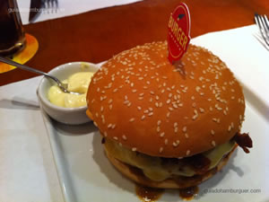 Barbecue Burger: hambúrguer de 150g com queijo prato derretido, bacon crocante, cebola grelhada e molho barbecue no pao com gergelim